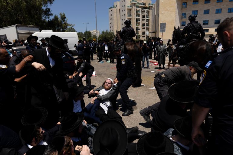 getty_682349a670-1747143078 RAMAT GAN, ISRAEL - AUGUST 5: Ultra-Orthodox Jewish men clash with police officers during a demonstration against drafting to the Israeli military near a recruitment base on August 5, 2024 in the Tel HaShomer area of Ramat Gan, Israel. Hundreds of Ultra-Orthodox men who were previously exempted from military service were due to arrive at the recruitment office here today, following a Supreme Court ruling that ended the exemption for yeshiva students. (Photo by Amir Levy/Getty Images)