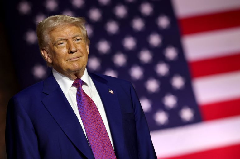 getty_6825d21120-1747309073 DOHA, QATAR - MAY 15: U.S. President Donald J. Trump stands on stage as he tours the Al Udeid Air Base on May 15, 2025, in Doha, Qatar. Trump is on the third day of his visit to the Gulf to underscore the strategic partnership between the United States and Qatar, focusing on regional security and economic collaboration. (Photo by Win McNamee/Getty Images)