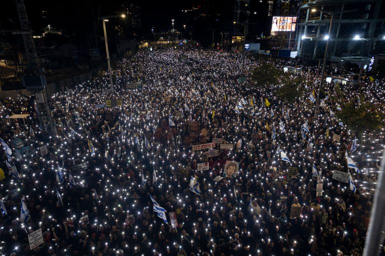 getty_682719a61a-1747392934 TEL AVIV, ISRAEL - MARCH 22: Protesters raise their phones during a rally against the Israeli government and demanding the release of all hostages held in the Gaza Strip on March 22, 2025 in Tel Aviv, Israel. Israelis take to the streets tonight calling for a new ceasefire in Gaza and to protest against what they consider to be an attack on the country's democracy by the rightwing coalition of Benjamin Netanyahu's governement. (Photo by Amir Levy/Getty Images)