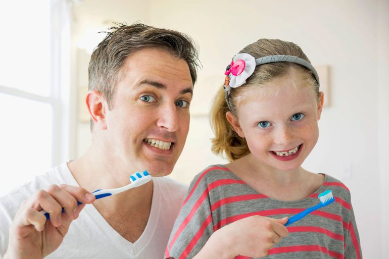 gettyimages-508483685-c2opy Caucasian father and daughter brushing their teeth