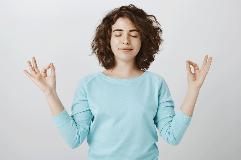peaceful-relaxed-1745702747 المصدر: فريبيك التوتر مُعدٍ.. كيف تحمي نفسك من عدواه؟ Peaceful and relaxed smiling woman with closed eyes meditating to find nirvana