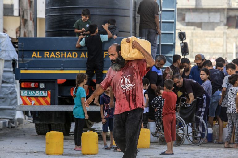 KHAN YUNIS, GAZA - MAY 11: Displaced Palestinians, including children receive clean water from a humanitarian aid truck in Khan Yunis, southern Gaza, where access to safe drinking water remains a major challenge due to the destruction of wells and water storage facilities amid ongoing Israeli attacks in Khan Yunis, Gaza on May 11, 2025. (Photo by Abed Rahim Khatib/Anadolu via Getty Images)