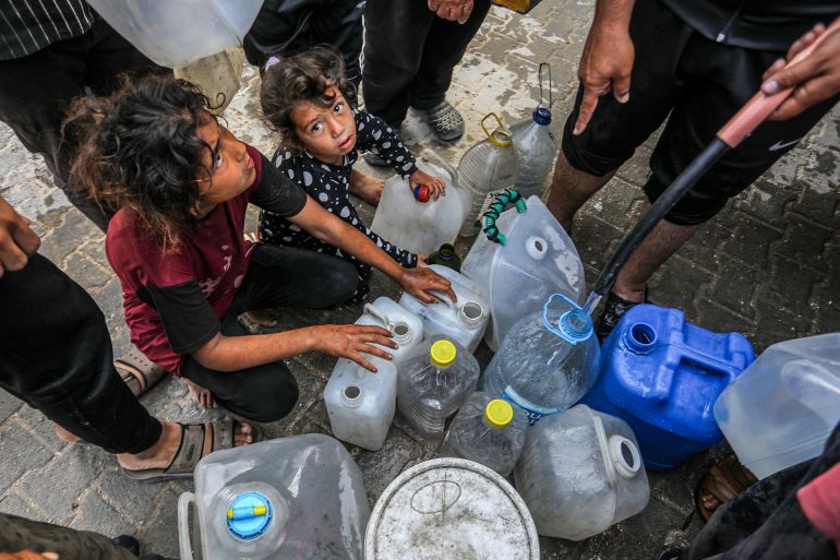 KHAN YUNIS, GAZA - MAY 11: Displaced Palestinians, including children receive clean water from a humanitarian aid truck in Khan Yunis, southern Gaza, where access to safe drinking water remains a major challenge due to the destruction of wells and water storage facilities amid ongoing Israeli attacks in Khan Yunis, Gaza on May 11, 2025. (Photo by Abed Rahim Khatib/Anadolu via Getty Images)