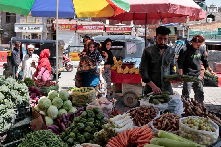 reuters_68224194-1747075477 People walk as vendors arrange vegetables on a roadside stall in Srinagar, Indian Kashmir, May 12, 2025. REUTERS/Sharafat Ali