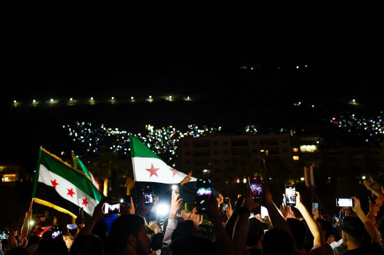 reuters_682460a5-1747214501 People celebrate after U.S. President Donald Trump said on Tuesday he would order the lifting of sanctions on Syria, in Damascus, Syria May 13 , 2025. REUTERS/Yamam Al Shaar