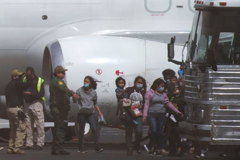 rthrth2-1745522391 Migrants leave a chartered flight that arrived from Brownsville, Texas in the Rio Grande Valley, while en route to be deported to Juarez, Mexico, at El Paso International Airport in El Paso, Texas, U.S. March 16, 2021. Picture taken through a fence. REUTERS/Paul Ratje TPX IMAGES OF THE DAY