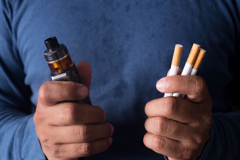 shutterstock_2162712117-1715759402 Concept of choosing the type of cigarette, a man's hand holds both types of cigarettes to choose from.