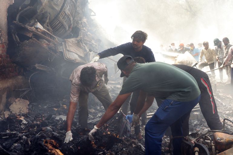TOPSHOT - Rescue officials work at the site where Air India flight 171 crashed in a residential area near the airport in Ahmedabad on June 12, 2025.
