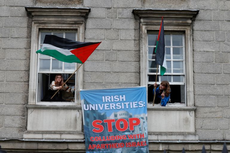 Students lean out of Trinity College Dublin's windows waving Palestinian flags during a protest calling for the government to impose sanctions on Israel, during a demonstration in solidarity with Palestinians in Gaza and Lebanon, amid the Israel-Hamas conflict, in Dublin, Ireland November 9, 2024. REUTERS/Clodagh Kilcoyne