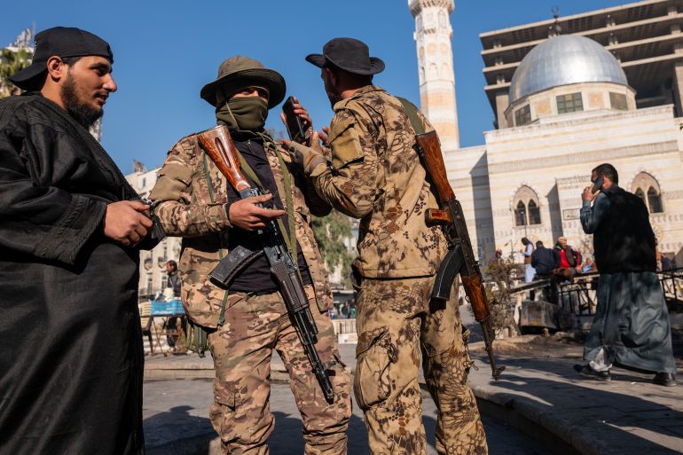 getty_683dcc9866-1748880536 DAMASCUS, SYRIA - JANUARY 19: Members of the insurgent group Hayat Tahrir al-Sham, or HTS, stand in a square on January 19, 2025 in Damascus, Syria. Following the overthrow of Syrian leader Bashar al-Assad by opposition groups in a quick offensive on December 8, the country is looking to gain economic momentum after years of global sanctions on the Assad-led government. Arab and Western countries have been reopening diplomatic relations with Syria's new de facto authorities, headed by the Islamist group HTS. Fourteen years of war have left the Syrian economy damaged, with tens of thousands of residents living on or below the poverty line. The World Food Program estimates that 13.1 million Syrians do not have enough to eat. (Photo by Spencer Platt/Getty Images)