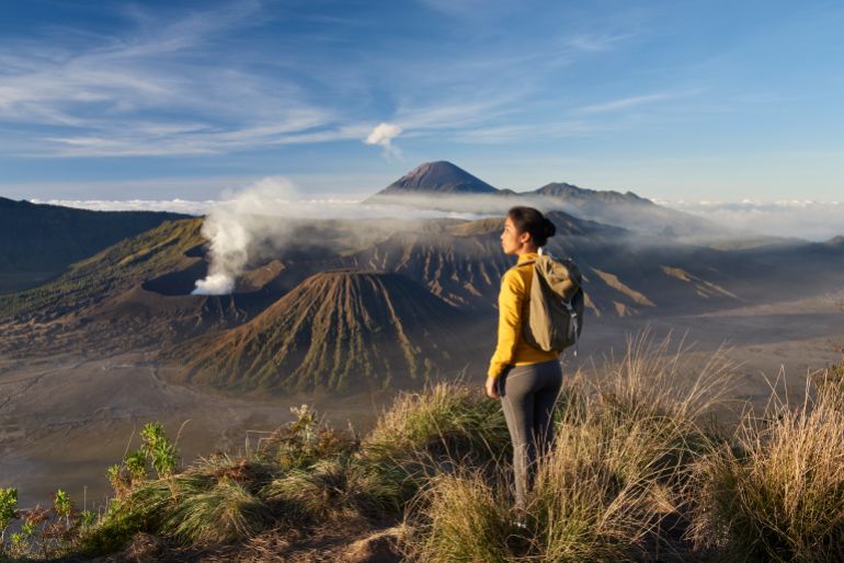 gettyimages-2173695040-1748950528 Asia, Indonesia, Java, Bromo Semeru national park, woman trekking at mount Bromo at sunrise, admiring view