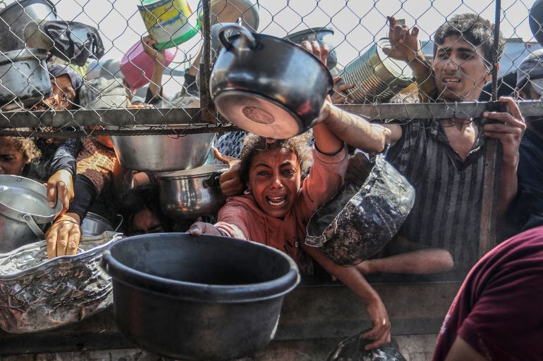 gettyimages-2217049544-1748973578-1 KHAN YUNIS, GAZA - MAY 30: Displaced Palestinians including women and children living in tents receive food distributed by aid organizations in al Mawasi district of Khan Yunis, Gaza on May 30, 2025 The situation highlights the growing desperation and urgent need for humanitarian assistance in the besieged enclave. (Photo by Abed Rahim Khatib/Anadolu via Getty Images)