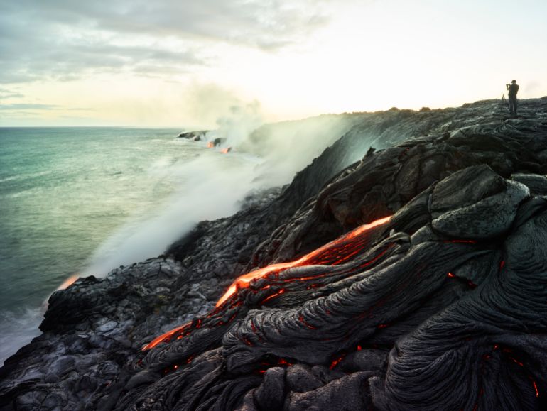 gettyimages-961107380-1748950477 30-40 years; adults; big island; catastrophe; caucasian; cloud; colour; dramatic; experience; experiencing; hawaii; heat; lava field; man; mid adults; ocean; smoke; traveller; unusual; view; volcanism; volcanoes national park