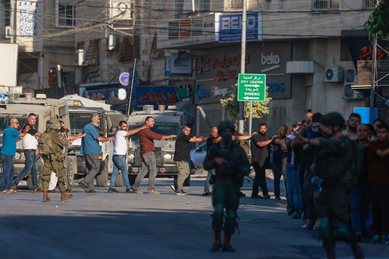 Israeli soldiers detain Palestinians during a raid following the reported explosion of an Israeli military vehicle near a checkpoint west of Tulkarem in the occupied West Bank on September 11, 2025