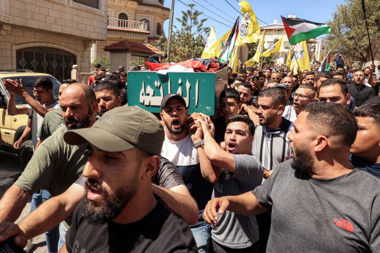 EDITORS NOTE: Graphic content / TOPSHOT - Mourners carry the body of Mohamed Alawi, a 21-year-old Palestinian who died from injuries during clashes with Israeli settlers in a reported attack near the village of Deir Jarir northeast of Ramallah in the occupied West Bank, during his funeral in the village on September 14, 2025.