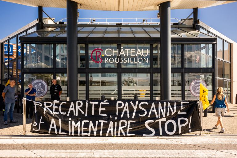 A banner reading "Farmers' and food insecurity. Stop !" hangs outside the Carrefour Chateau Roussillon store and supermarket in Perpignan, southeastern France, on September 10, 2025, during its blockage as part of the "Bloquons tout" ("Let's block everything") protest movement, in Le Boulou, southwestern France, on September 10, 2025.