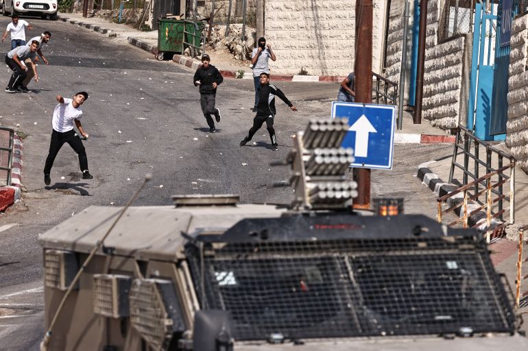 afp_68cbb5adb49d-1758180781 TOPSHOT - Palestinian throw rocks at Israeli soldiers during a raid on Ramallah city in the occupied West Bank on September 16, 2025.
