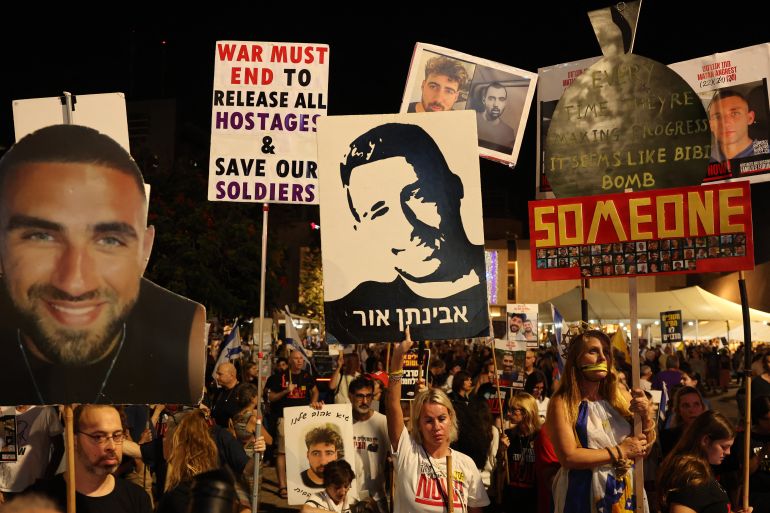 Protesters carry signs during a demonstration organised by the families of Israelis held hostage by Palestinian militants in the Gaza Strip, to call for their release and for a ceasefire in the war in Gaza, at 'Hostage Square' in Tel Aviv on September 13, 2025.