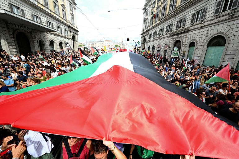 People march with a giant Palestinian flag during a nationwide strike "Let's Block Everything" in solidarity with Palestinians in Gaza and calling for a halt to arms shipments to Israel, in Rome on September 22.