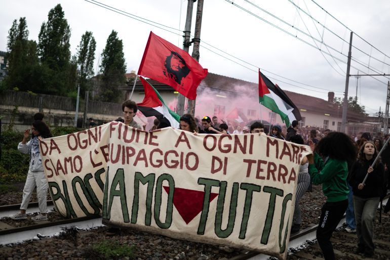 Pro-Palestinians protesters hold a banner reading “Let's block everything” as they walk on railway tracks during a nationwide strike organized by the Unione Sindacale di Base (USB Union) in Turin, northwestern Italy on September 22, 2025.