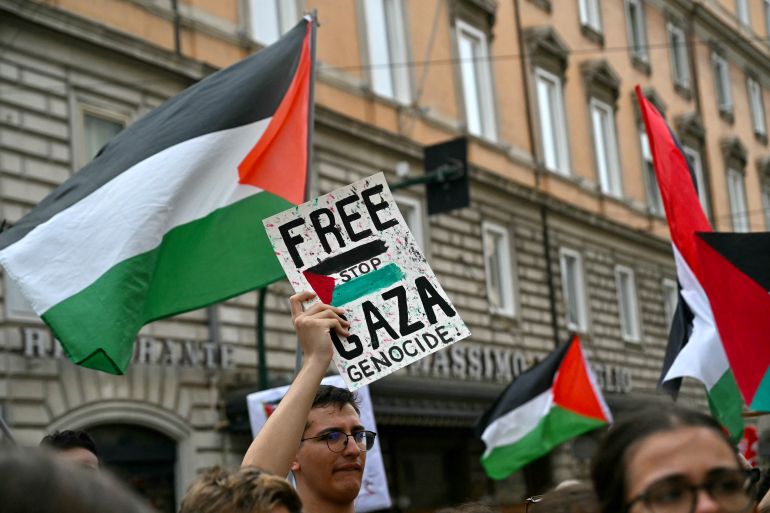 People hold Palestinian flags and placards "Free Gaza - Stop Genocide" during a protest part of the nationwide strike "Let's Block Everything" in solidarity with Palestinians in Gaza and calling for a halt to arms shipments to Israel, in Rome on September 22.