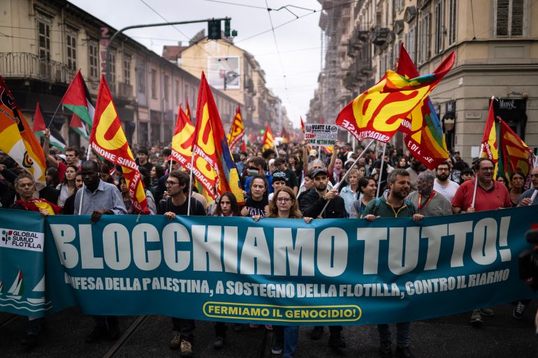 Pro-Palestinians protesters wave USB flags and hold a banner reading “Let's Block Everything!" during a nationwide strike organized by the Unione Sindacale di Base (USB Union) in Turin, northwestern Italy on September 22, 2025.