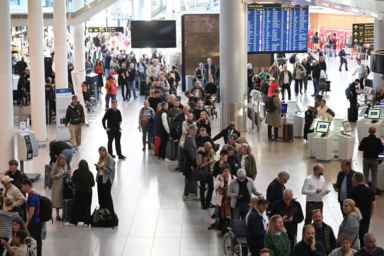 Passengers stand in a queue to get new tickets at the service point of the Copenhagen Airport in Copenhagen, Denmark, on September 23, 2025.