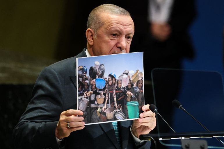 Turkey's President Recep Tayyip Erdogan holds up a photo of people in Gaza as he speaks during the General Debate of the United Nations General Assembly at the UN headquarters in New York City on September 23, 2025. (Photo by ANGELA WEISS / AFP)