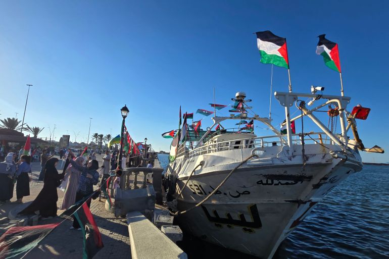 afp_68d42950abd5-1758734672 People pose for a picture in front of the Omar al-Mukhtar ship, a Libyan ship setting sail on September 17 to join the Global Sumud Flotilla, at the port in Tripoli on September 16, 2025.