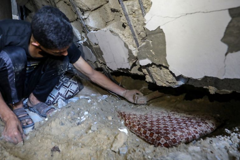 EDITORS NOTE: Graphic content / A Palestinian youth touches the hand of a child buried under the rubble of a building hit by an Israeli strike in the Nuseirat refugee camp in the central Gaza Strip, on September 25, 2025, as Israel presses its air and ground offensive to capture the nearby Gaza City.