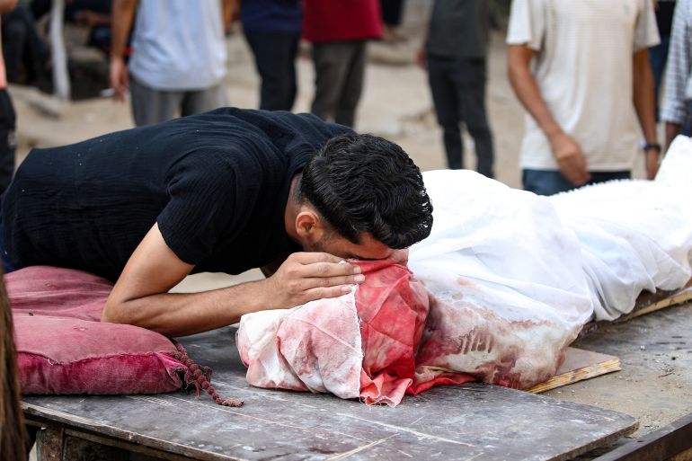 EDITORS NOTE: Graphic content / A Palestinian bids farewell to a man killed in Israeli bombing, in front of the al-Awda hospital in the Nuseirat refugee camp in the central Gaza Strip, on September 28, 2025.
