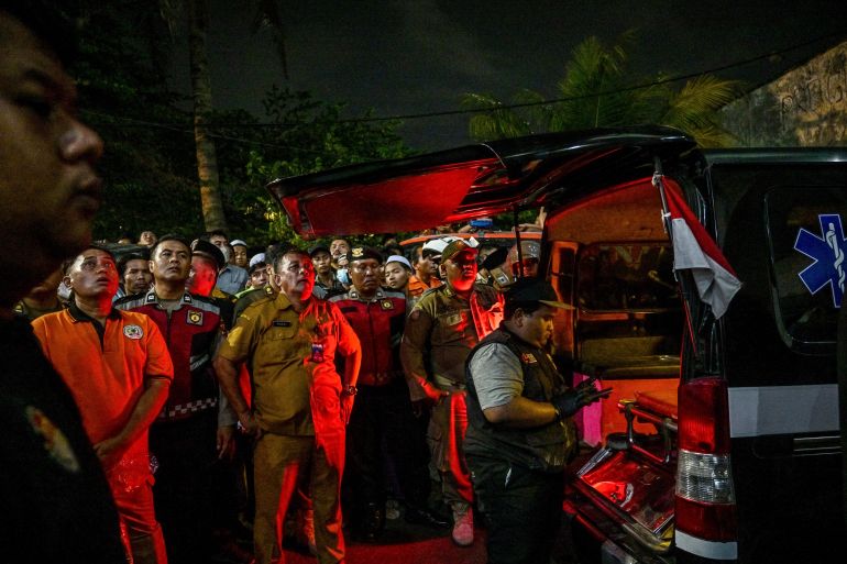 afp_68db671e192e-1759209246 Medical personnel wait beside an ambulance as rescue personnel search for survivors after a building collapsed at an Islamic boarding school in Sidoarjo, East Java province on September 29, 2025, injuring a number of students and trapping several others under the rubble.