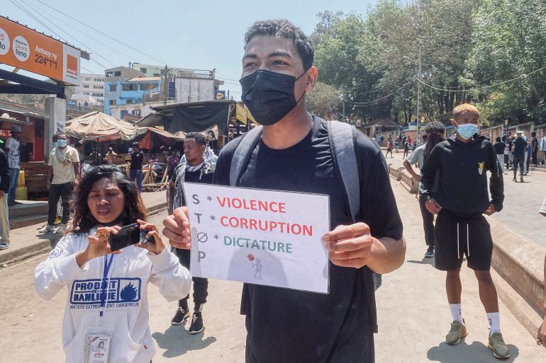 A protester holds a placard as he gathers with other protesters during a demonstration against repeated water and electricity outages in Antananarivo on September 29, 2025.