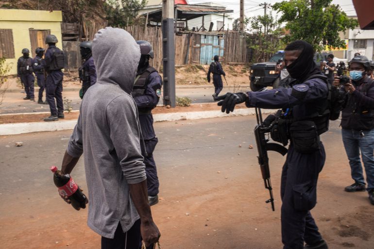 A man is questioned by a security officer as protesters gather during a demonstration against repeated water and electricity outages in Antananarivo on September 29, 2025.