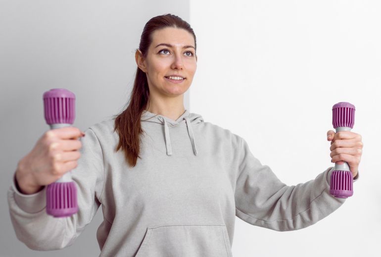 asdasdsad3-1759154848 Medium shot woman holding dumbbells freepik