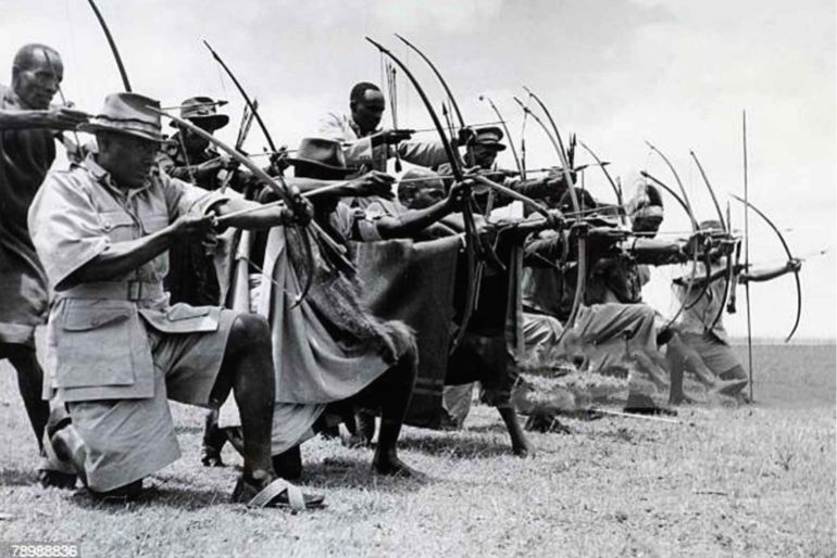 War and Conflict, Mau May Uprising, Kenya, East Africa, pic: 1953, Men of the Kikuyu Home Guard show their prowess with bow and arrow as they exercise near Githunguri in the battle against Mau Mau terrorists (Photo by Popperfoto via Getty Images/Getty Images)