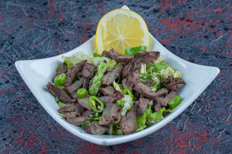 A white plate with delicious meat and herbs فري بيك