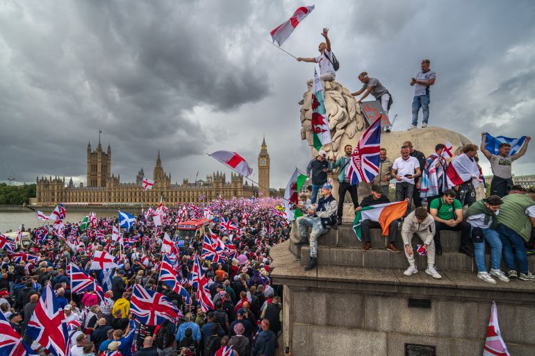 getty_68c64ce1b3-1757826273 LONDON, ENGLAND - SEPTEMBER 13: Protesters wave Union Jack and St George's England flags during the "Unite The Kingdom" rally on Westminster Bridge by the Houses of Parliament on September 13, 2025 in London, England. Far-right activist Tommy Robinson (also known as Stephen Yaxley-Lennon) has invited supporters to hold a rally in central London entitled "Unite The Kingdom". The former English Defence League leader and his supporters are actively islamophobic and racist and have been behind much of the unrest seen outside hotels housing migrants this summer. Stand Up To Racism are mounting a counter-protest to today's rally. (Photo by Christopher Furlong/Getty Images)