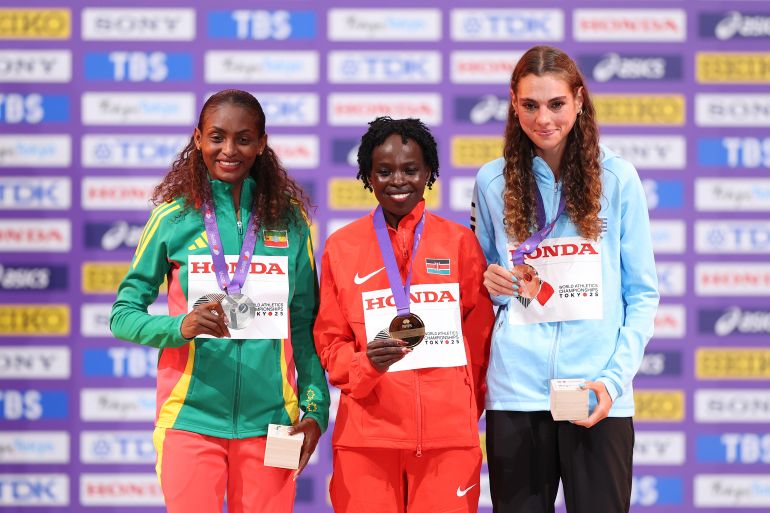 getty_68c7c62a03-1757922858 TOKYO, JAPAN - SEPTEMBER 14: (L-R) Silver medalist Tigst Assefa of Team Ethiopia, Gold medalist Peres Jepchirchir of Team Kenya and Bronze medalist Julia Paternain of Team Uruguay pose for a photo on the podium during the Women's Marathon medal ceremony on day two of the World Athletics Championships Tokyo 2025 at National Stadium on September 14, 2025 in Tokyo, Japan. (Photo by Emilee Chinn/Getty Images)