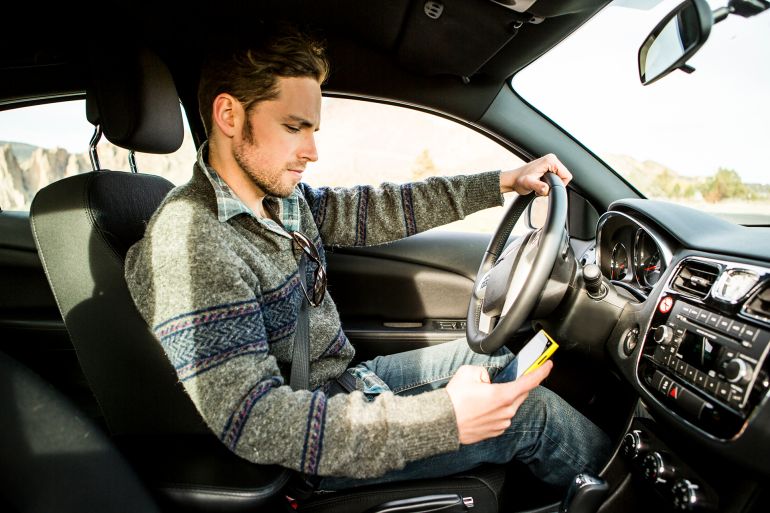 gettyimages-487580219-1758383439 A man sending a text while driving.