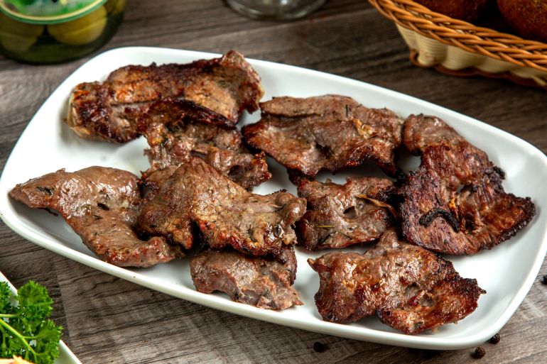 Side view meat basturma kebab on a plate with bread فري بيك