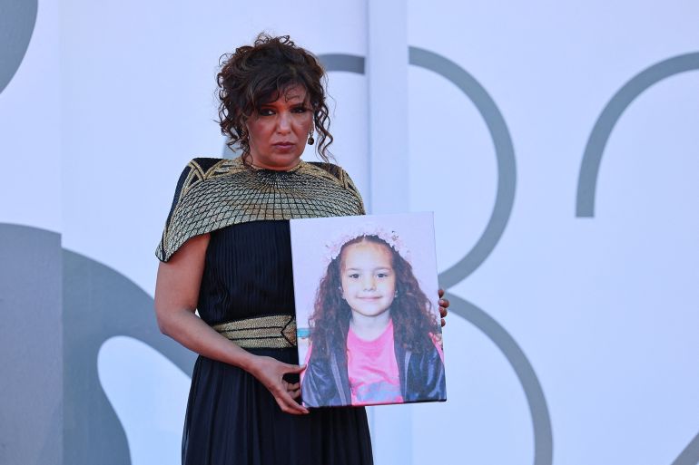 Kaouther Ben Hania poses with a picture of Hind Rajab on the red carpet during arrivals for the screening "The Voice of Hind Rajab" in competition, at the 82nd Venice Film Festival, Venice, Italy, September 3, 2025. REUTERS/Yara Nardi