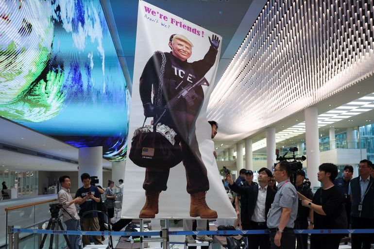 An activist reacts as he holds a banner to protest against a huge immigration raid last week at the site of a U.S. car battery project involving Hyundai Motor and LG Energy Solution in the U.S. state of Georgia, at the Incheon International Airport in Incheon, South Korea, September 12, 2025. REUTERS/Kim Hong-ji