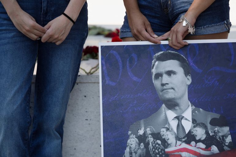 reuters_68c42005-1757683717 Jordyn Hackner, president of Turning Point USA's University of Houston chapter,and Lizbeth Aguilar stand behind a poster of conservative activist Charlie Kirk as people mourn following his fatal shooting, at the University of Houston in Houston, Texas, U.S., September 11, 2025. REUTERS/Antranik Tavitian TPX IMAGES OF THE DAY