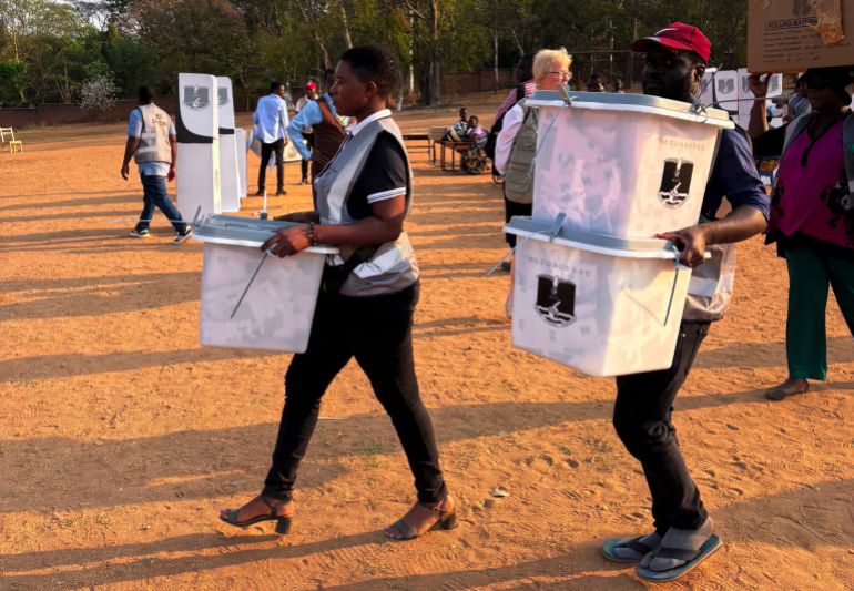 Election officials carry ballot boxes at the end of voting day in the country's general election in Lilongwe, Malawi, September 16, 2025. REUTERS/Thando Hlophe