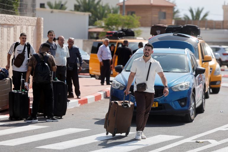Palestinians walk with their belongings as they wait near the Allenby Bridge Crossing in the Israeli-occupied West Bank to travel to Jordan, after Israeli Airports Authority said it will be re-opened on Friday, September 26,2025. REUTERS/Ammar Awad