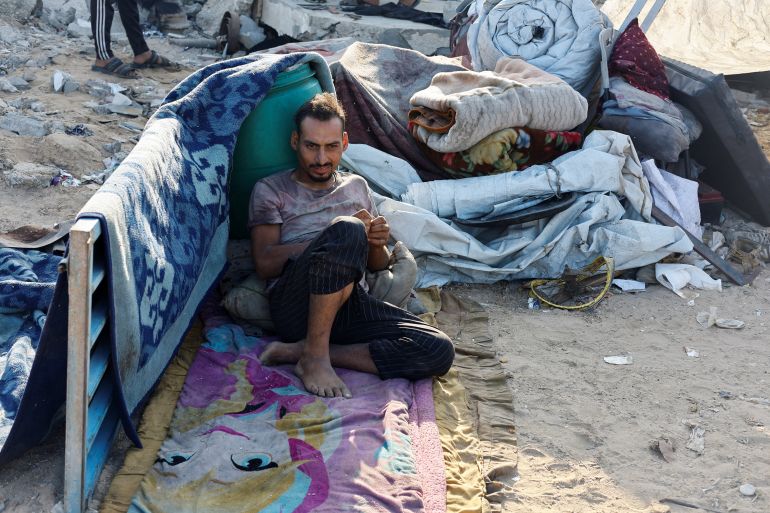 A displaced Palestinian man, who fled northern Gaza after Israeli forces ordered residents of Gaza City to evacuate to the south amid Israeli military operation, rests next to his belongings as he temporarily shelters on a roadside, in the central Gaza Strip, September 27, 2025. REUTERS/Mahmoud Issa