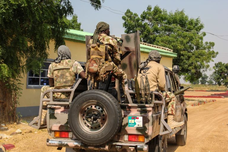 000_8ul6y6 Nigerian Army soldiers are seen driving on a military vehicle in Ngamdu, Nigeria, on November 3, 2020. Audu Marte / AFP