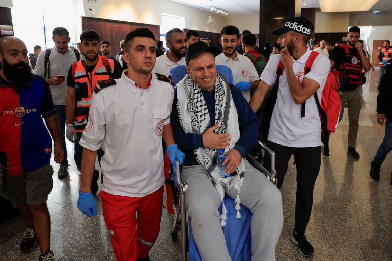 202oners-1760353873 Palestine Red Crescent Society (PRCS) members move a freed Palestinian prisoner to a hospital as he reacts after being released from an Israeli jail as part of a hostages-prisoners swap and a ceasefire deal in Gaza between Hamas and Israel, in Ramallah, in the Israeli-occupied West Bank, October 13, 2025. REUTERS/Mussa Qawasma