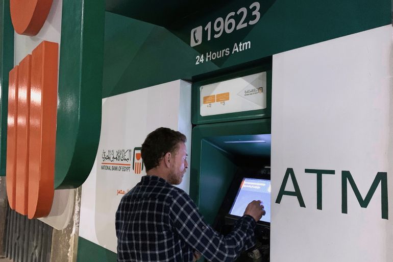 A man withdraws money from an ATM machine at the National Bank of Egypt (NBE) in Cairo, Egypt, April 23, 2020. REUTERS/Mohamed Abd El Ghany